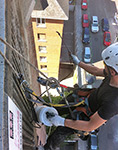 Trabajos de limpieza de celosías en fachada de edificio de viviendas en Madrid.